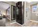 Bedroom leading to a connected bath with a tiled shower and dark wood accents at 5311 S Danube Ct, Centennial, CO 80015