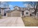 Charming two-story home featuring a three-car garage, stone accents, and a well-manicured lawn at 5311 S Danube Ct, Centennial, CO 80015