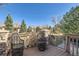Inviting back deck with charming wicker chairs surrounded by mature trees at 16494 Aliante Dr, Broomfield, CO 80023
