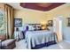 Bedroom with tray ceiling, patterned bedding, sitting area and view to ensuite bathroom at 16494 Aliante Dr, Broomfield, CO 80023