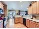 Open kitchen with wooden cabinets, appliances and view to dining area with access to patio at 16494 Aliante Dr, Broomfield, CO 80023