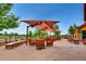 Outdoor patio featuring comfortable seating under shade structures near a peaceful pond and green space at 16494 Aliante Dr, Broomfield, CO 80023