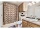 Functional bathroom with a shower and tub, a vanity sink, and wooden cabinets at 814 S Vance St # F, Lakewood, CO 80226