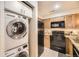 Efficient kitchen layout with stackable washer and dryer, plus black appliances at 814 S Vance St # F, Lakewood, CO 80226