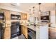 Functional kitchen featuring black appliances and a breakfast bar overlooking the living room at 814 S Vance St # F, Lakewood, CO 80226