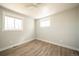 Bright bedroom featuring two windows and contemporary flooring at 6671 Oneida St, Commerce City, CO 80022