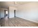 A bright bedroom features a ceiling fan, neutral walls, and light hardwood flooring at 6671 Oneida St, Commerce City, CO 80022