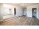 Open-concept living room featuring hardwood floors, neutral paint, and a seamless flow to the kitchen at 6671 Oneida St, Commerce City, CO 80022