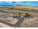 A picturesque aerial view of the property, with the home and barn set against the backdrop of rolling hills at 11549 Haskell Creek Rd, Larkspur, CO 80118