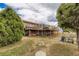 A backyard featuring multiple decks, hot tub, outdoor seating, and expansive yard at 11549 Haskell Creek Rd, Larkspur, CO 80118