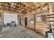 View of a barn interior featuring wooden stalls, high ceilings, and large sliding door at 11549 Haskell Creek Rd, Larkspur, CO 80118