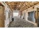 This shows an indoor shot of a barn, featuring an open, exposed beam ceiling, and an open garage door at the end at 11549 Haskell Creek Rd, Larkspur, CO 80118