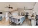 Open kitchen with blue island, stainless appliances and modern white cabinetry for a bright cooking space at 11549 Haskell Creek Rd, Larkspur, CO 80118