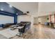 Spacious basement living room with a screen, leather sofa and wood-look flooring at 11549 Haskell Creek Rd, Larkspur, CO 80118