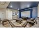 Comfortable living room featuring a sectional sofa, a large window, and a view of the screen at 11549 Haskell Creek Rd, Larkspur, CO 80118