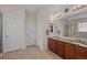 Bathroom featuring a dual sink vanity with granite countertops, a mirror, and a walk-in shower at 15271 Grasslands Dr, Parker, CO 80134