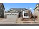 Charming single-Gathering home with stone accents, gray siding, and a well-maintained front yard and driveway at 15271 Grasslands Dr, Parker, CO 80134