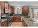 Gourmet kitchen featuring granite counters, stainless appliances, wood cabinets, and a tile backsplash at 15271 Grasslands Dr, Parker, CO 80134