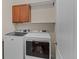 Bright laundry room with wood cabinets and white Maytag washer and dryer set at 15271 Grasslands Dr, Parker, CO 80134