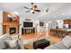 Inviting living room features a cozy fireplace, hardwood floors, ceiling fan, and opens to the dining area at 15271 Grasslands Dr, Parker, CO 80134