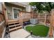Fenced backyard features small deck, manicured artificial lawn, and patio at 1699 S Trenton St # 69, Denver, CO 80231