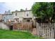 Spacious backyard features green lawn, wooden fence, patio, and the exterior of the home at 1699 S Trenton St # 69, Denver, CO 80231