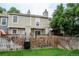 View of the backyard showcasing a wooden fence, deck, and the exterior of the home at 1699 S Trenton St # 69, Denver, CO 80231