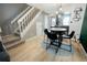 Bright dining area featuring hardwood floors, modern lighting, and a view of the adjacent kitchen and staircase at 1699 S Trenton St # 69, Denver, CO 80231