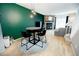 Open-concept dining area with hardwood floors, modern lighting, and a green accent wall at 1699 S Trenton St # 69, Denver, CO 80231