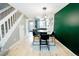 Bright dining area features hardwood floors, modern lighting, and a view of the adjacent kitchen and staircase at 1699 S Trenton St # 69, Denver, CO 80231