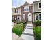 Charming townhouse featuring a well-manicured lawn and inviting entryway with concrete stairs and black railings at 1699 S Trenton St # 69, Denver, CO 80231
