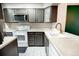Galley kitchen with stainless steel appliances and modern white countertops at 1699 S Trenton St # 69, Denver, CO 80231