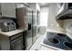 A galley kitchen with stainless steel refrigerator and stackable washer and dryer at 1699 S Trenton St # 69, Denver, CO 80231
