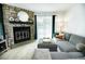 Bright living room featuring a stone fireplace, hardwood floors, and a comfortable gray sectional sofa at 1699 S Trenton St # 69, Denver, CO 80231