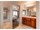 Bright bathroom featuring a glass enclosed shower, bedroom access, and wood vanity at 463 Mazzini St, Erie, CO 80516