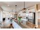 Modern kitchen with stainless steel appliances and island, open to dining area at 463 Mazzini St, Erie, CO 80516
