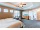 Bedroom with trey ceilings, ceiling fan, natural light and relaxing chair near a window at 463 Mazzini St, Erie, CO 80516
