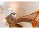 Upper view of curved staircase with hardwood flooring, decorative chandelier, and cozy seating area below at 463 Mazzini St, Erie, CO 80516