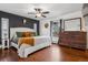 Comfortable main bedroom with hardwood floors, rustic furniture, accent wall and a ceiling fan at 8170 Lt William Clark Rd, Parker, CO 80134