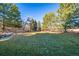 Beautifully landscaped backyard with mature trees, a lush lawn, and privacy at 9 Mule Deer Trl, Littleton, CO 80127