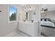 Bright bathroom featuring double sinks, a large mirror, and a serene view at 9 Mule Deer Trl, Littleton, CO 80127