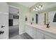 Bright bathroom featuring double sinks, white cabinets, and modern fixtures at 9 Mule Deer Trl, Littleton, CO 80127
