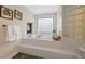 Bright bathroom with a soaking tub, glass block window, and decorative accents at 9 Mule Deer Trl, Littleton, CO 80127