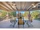 Relaxing covered deck with a dining set, ceiling fans, and a view of the landscaped backyard at 9 Mule Deer Trl, Littleton, CO 80127