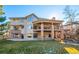 Exterior view of a two-story home featuring a large backyard, balcony and stone patio at 9 Mule Deer Trl, Littleton, CO 80127