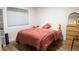Simple bedroom with window, full-sized bed, small dresser, and mirror at 3701 S Grant St, Englewood, CO 80113