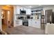 Clean and modern kitchen with white cabinets and stainless steel appliances, open to the dining area at 3701 S Grant St, Englewood, CO 80113
