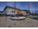 Beautiful backyard featuring a stone fire pit, covered patio, and outdoor seating area at 9521 Garnett Way, Arvada, CO 80007