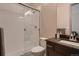 Bright bathroom with glass shower, white tiles, and vanity with dark countertop at 9521 Garnett Way, Arvada, CO 80007