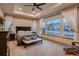 Main bedroom with tray ceiling, large windows, bench and dark wood furnishings at 9521 Garnett Way, Arvada, CO 80007